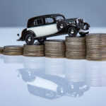 Toy car on top of coins representing Ford finance