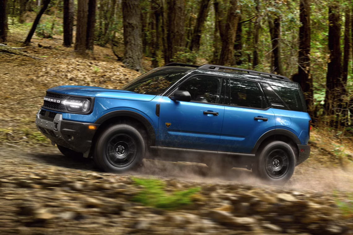 2026 Ford Bronco Sport driving through a forest on a trail.