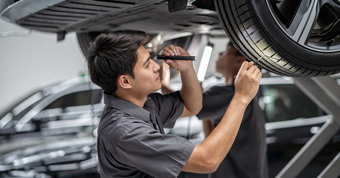 Ford service technician inspecting tire tread